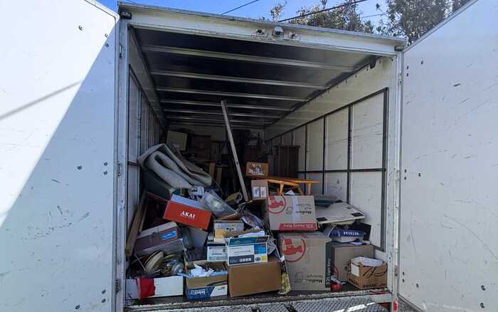 Inside a truck during an estate and home clear out packed with boxes and sorted items.