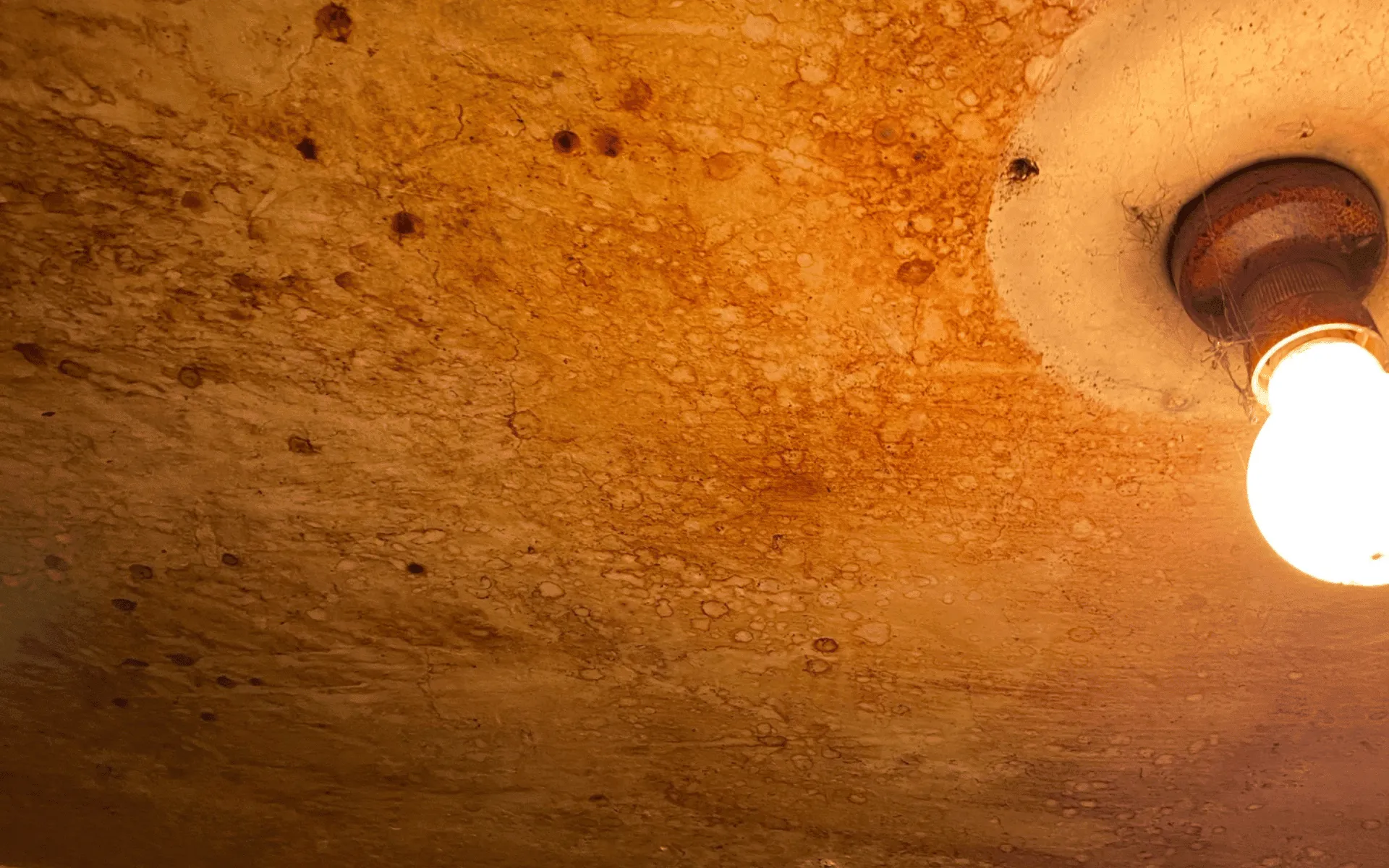 Severe smoke and nicotine staining on a ceiling before professional odour removal by AllAces.